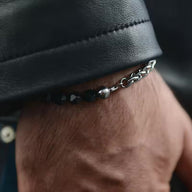 Bracelet homme en acier inoxydable avec perles noires facettées et chaîne argentée fine.
