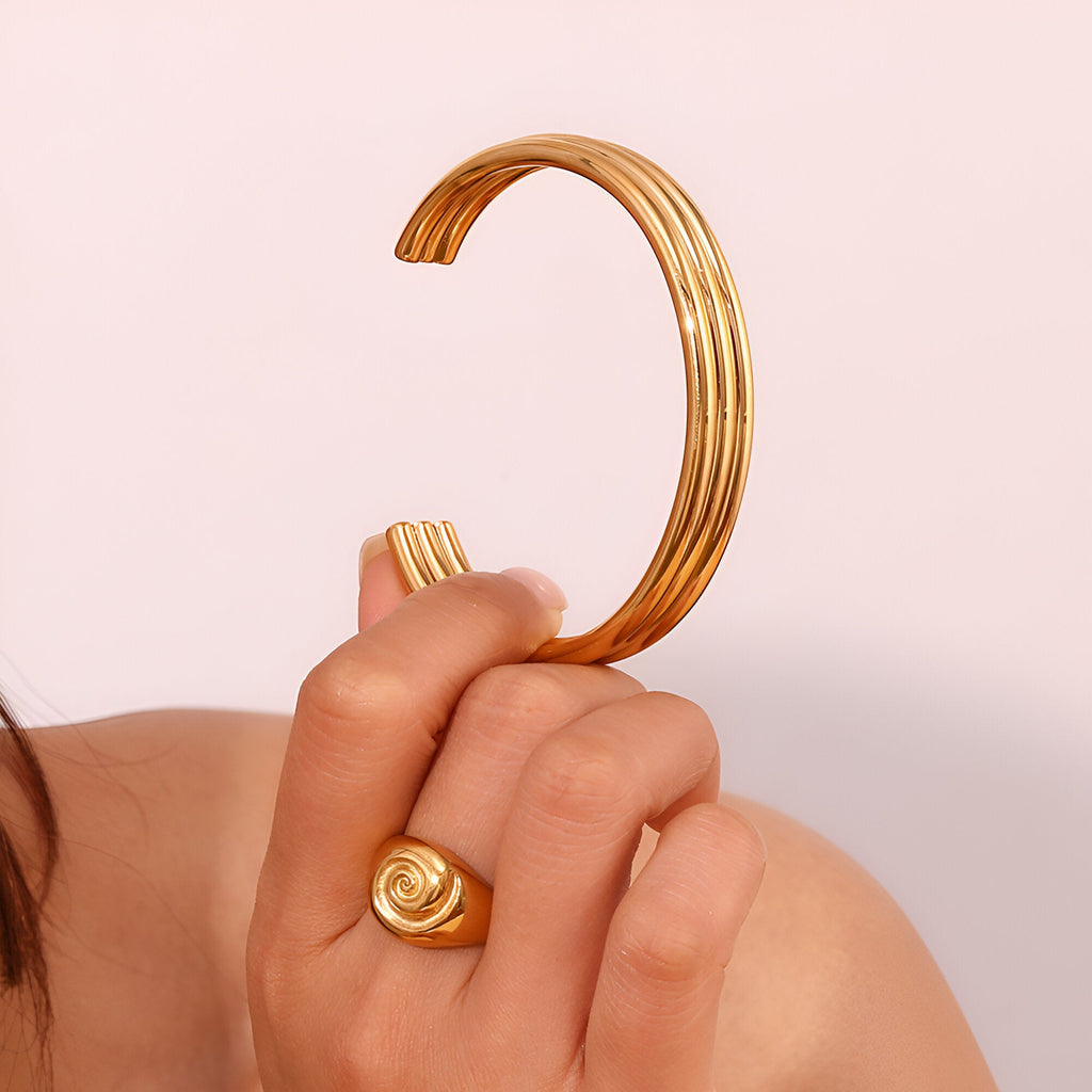 Bracelet jonc ouvert en acier inoxydable plaqué or 18 carats, design trilogie d'anneaux lisses.