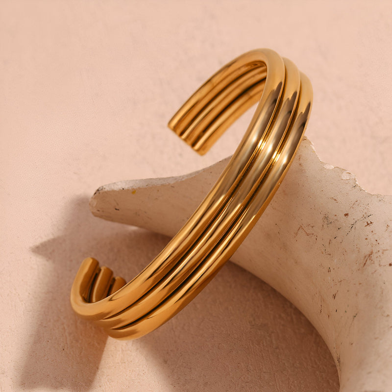 Bracelet jonc ouvert en acier inoxydable plaqué or 18 carats, trilogie d'anneaux lisses entrelacés.