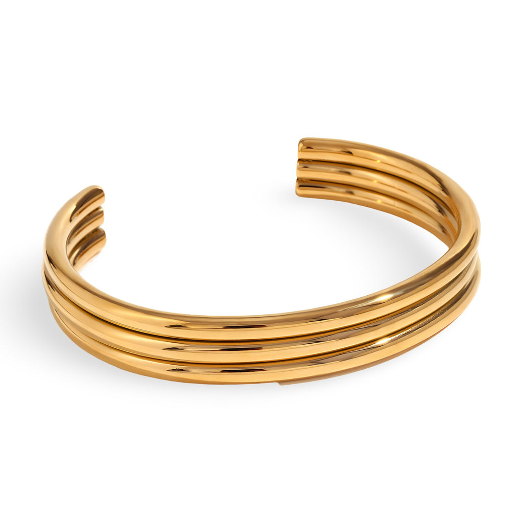 Bracelet jonc ouvert en acier inoxydable plaqué or 18 carats avec trois anneaux lisses et brillants.