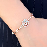 Bracelet en acier inoxydable or rosé avec pendentif arbre de vie rond et chaîne à maillons élégante.