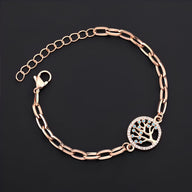 Bracelet or rosé en acier inoxydable avec pendentif arbre de vie orné de petites pierres brillantes.