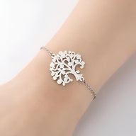 Bracelet fin en acier inoxydable argenté avec pendentif arbre de vie stylisé pour femme.
