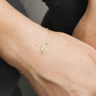Bracelet fin en acier inoxydable doré avec pendentif lune délicat, style minimaliste femme.