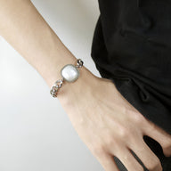 Bracelet homme en acier inoxydable argenté avec maillons larges et plaque centrale lisse.