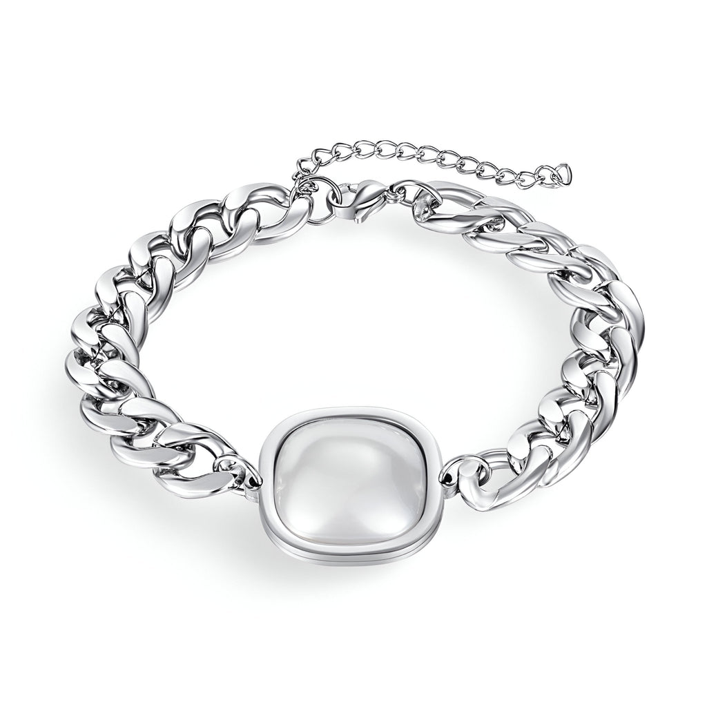 Bracelet en acier inoxydable argenté avec chaîne épaisse et plaque centrale lisse et brillante.