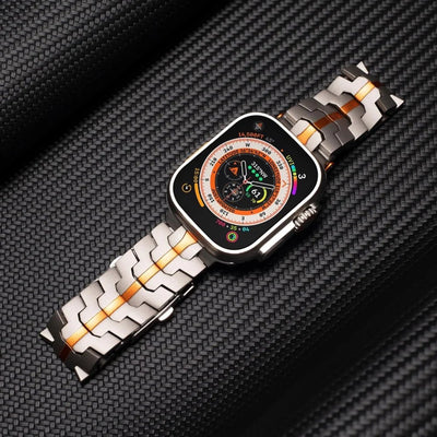 Bracelet pour Apple Watch en acier inoxydable gris avec touches orange, design ajustable haute technologie.