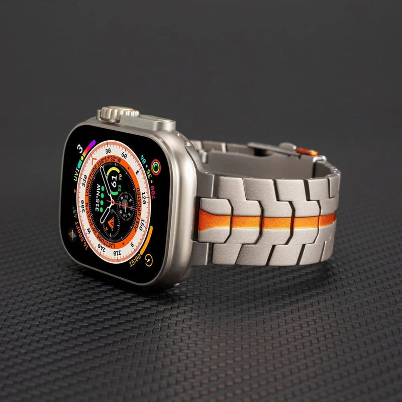 Bracelet acier inoxydable gris avec détails orange, pour Apple Watch, style robuste et ajustable.