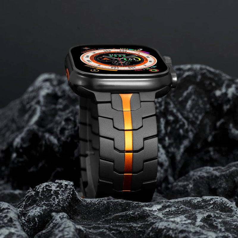 Bracelet Apple Watch en acier inoxydable noir avec bande centrale orange, design large et ajustable.