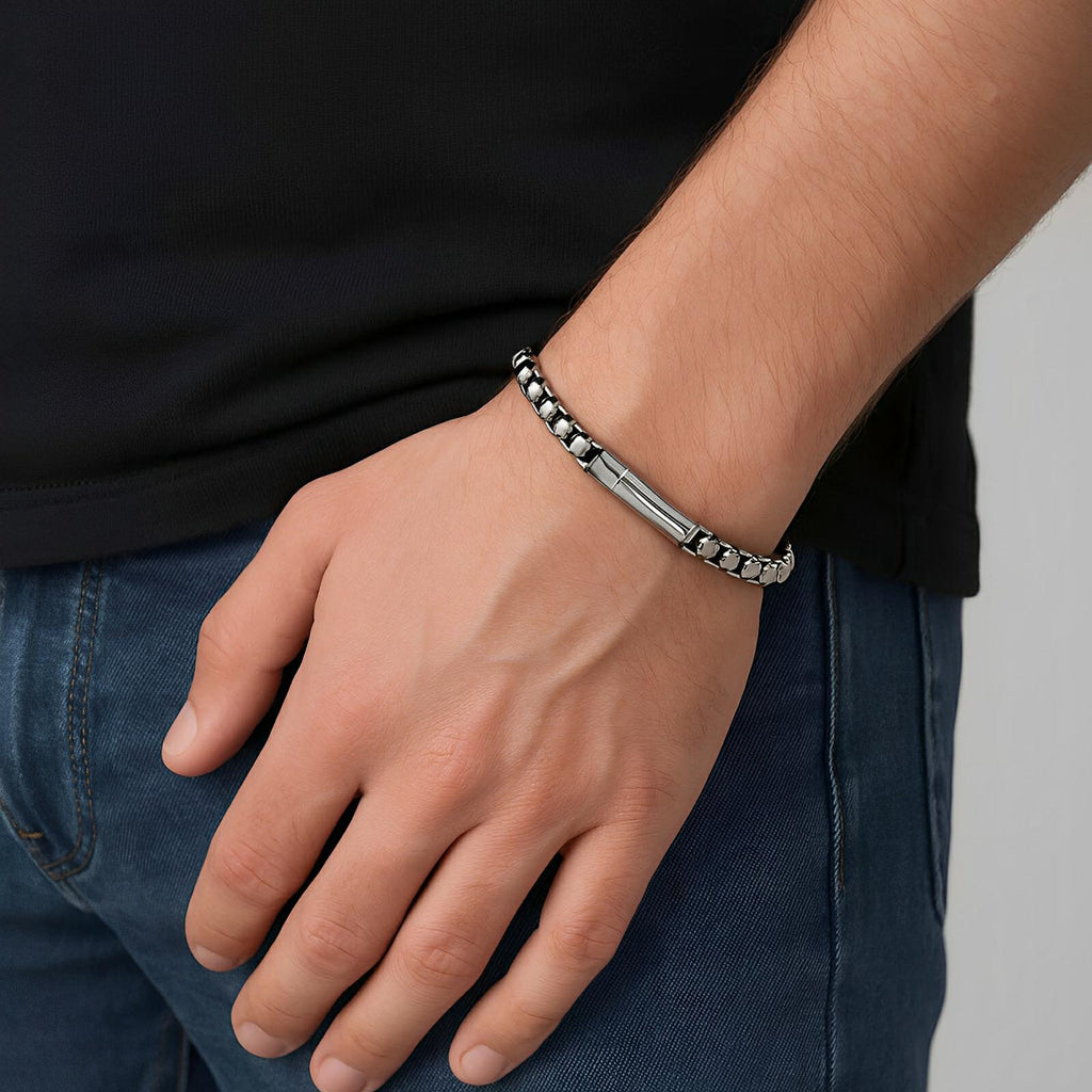 Bracelet en acier inoxydable argenté à maille rolo épaisse, style masculin, porté au poignet.
