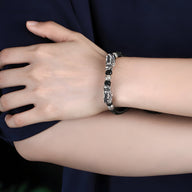 Bracelet en argent massif avec deux têtes de dragon détaillées, style masculin, finition brillante.