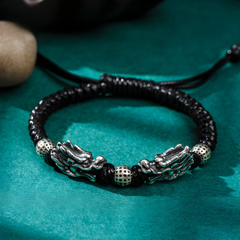 Bracelet homme en argent massif avec double tête de dragon et cordon noir tressé ajustable.