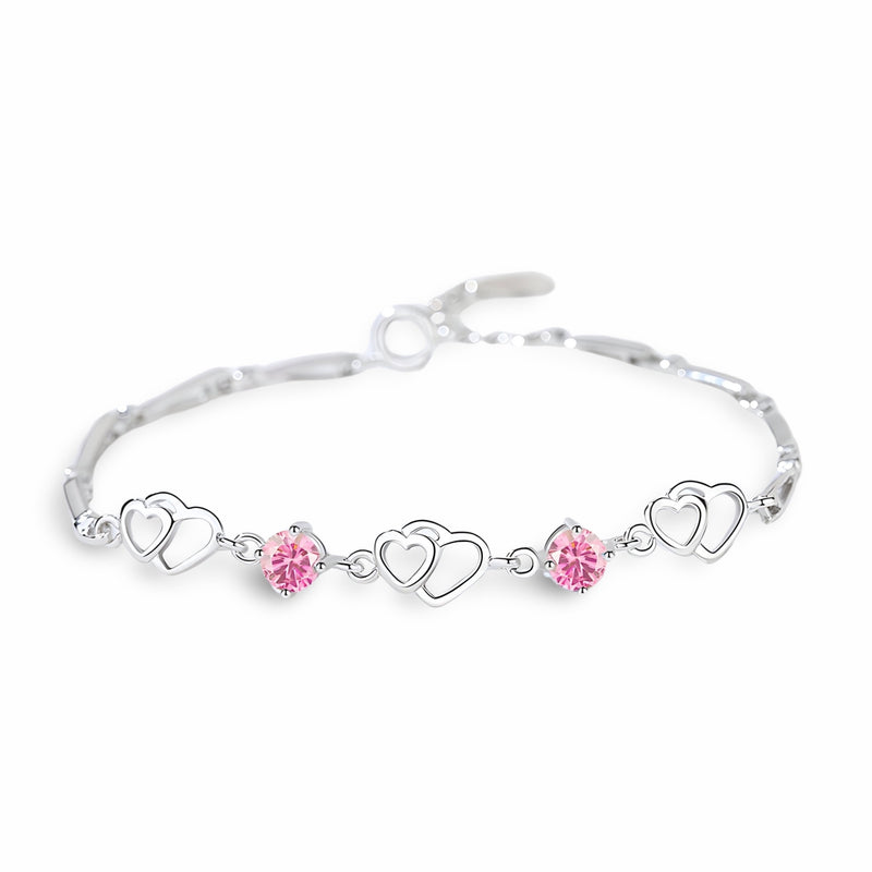 Bracelet en argent massif avec charms cœurs entrelacés et cristaux roses éclatants.