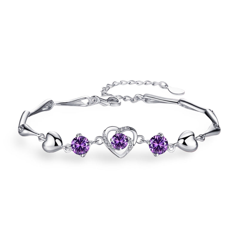 Bracelet en argent avec charmes cœur et pierres violettes serties, style délicat pour femme.