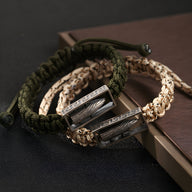Bracelet homme argent sterling avec balle militaire encadrée sur corde tressée verte et beige.