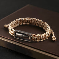 Bracelet homme en corde beige tressée avec balle militaire en argent sterling encadrée.