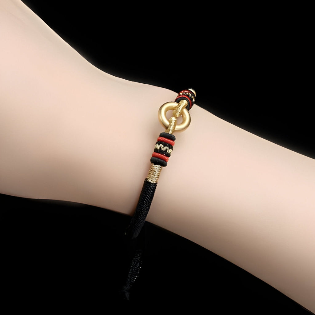 Bracelet fin noir en argent sterling avec cercle doré et nœud coulissant rouge, noir et beige.