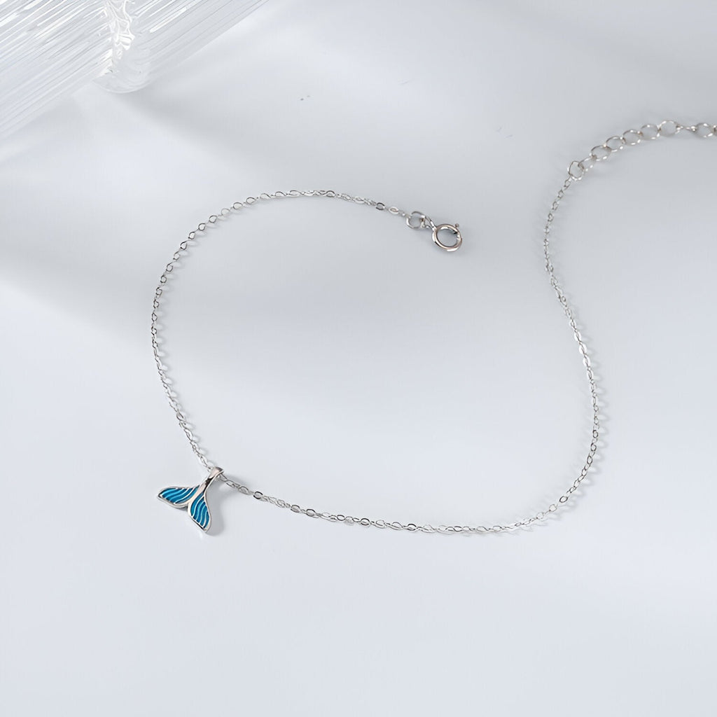 Bracelet fin en argent sterling avec pendentif charm queue de baleine bleu sur chaîne délicate.