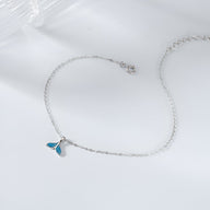Bracelet fin en argent sterling avec pendentif charm queue de baleine bleu sur chaîne délicate.