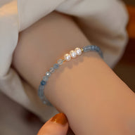 Bracelet fin en argent sterling avec perles d'aigue-marine bleu clair et quatre petites perles blanches délicates.