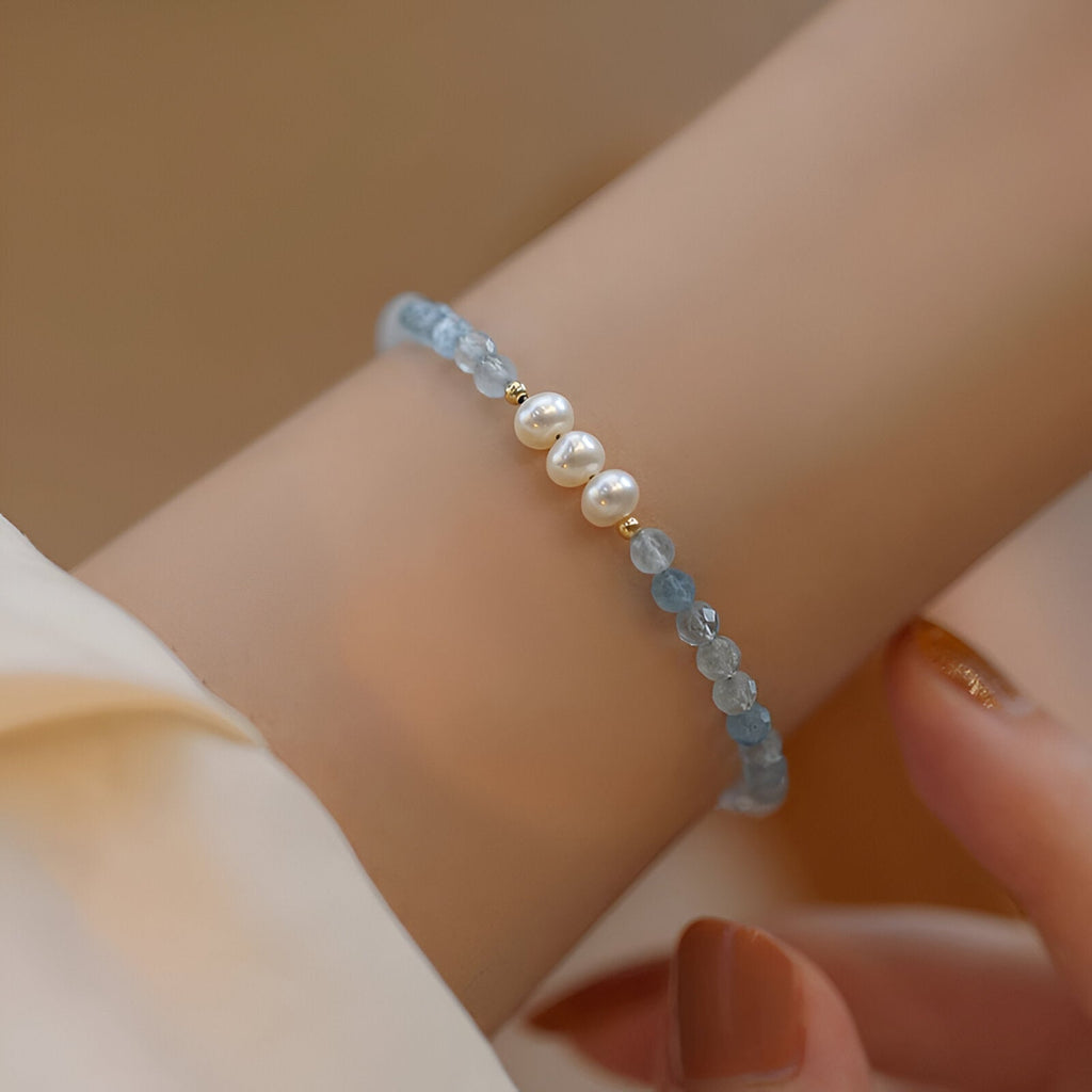 Bracelet fin en argent avec perles d'aigue-marine bleues et six perles blanches nacrées.