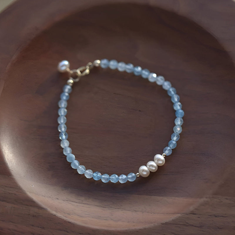Bracelet fin en argent sterling avec perles d'aigue-marine bleues et trois perles blanches centrales.
