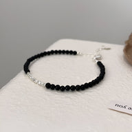 Bracelet fin en argent sterling avec perles d'onyx noir et fermoir ajustable.