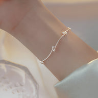 Bracelet fin en argent sterling avec noeud et petites perles délicates pour femme.