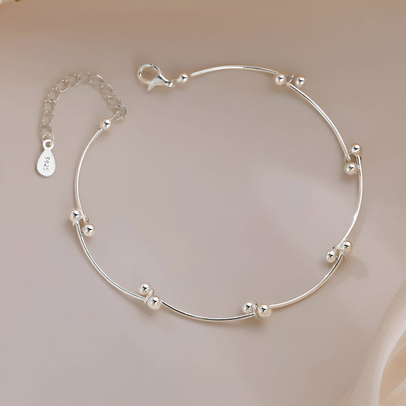 Bracelet fin en argent sterling avec noeud et perles arrondies élégantes.