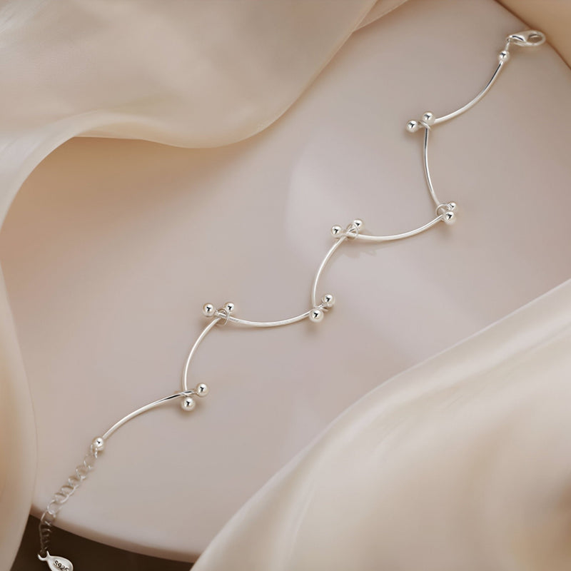 Bracelet en argent sterling avec design de nœuds perlés, style délicat et féminin.