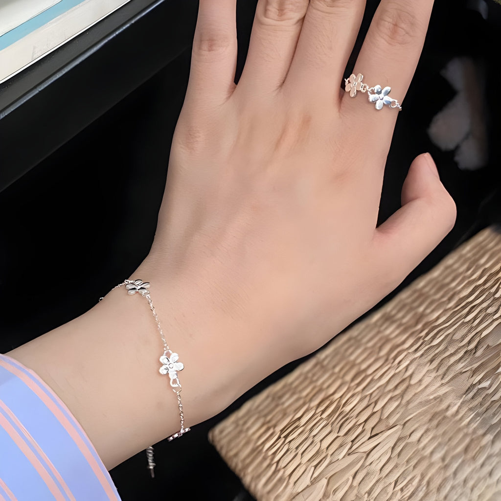 Bracelet en argent sterling avec ornement floral délicat porté sur poignet féminin.