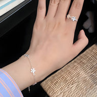 Bracelet en argent sterling avec ornement floral délicat porté sur poignet féminin.