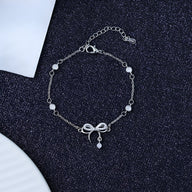 Bracelet en argent sterling avec ornement noeud délicat et petits pendentifs ronds.