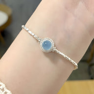 Bracelet en argent sterling avec pierre ronde d'aigue-marine bleue et chaîne fine élégante.