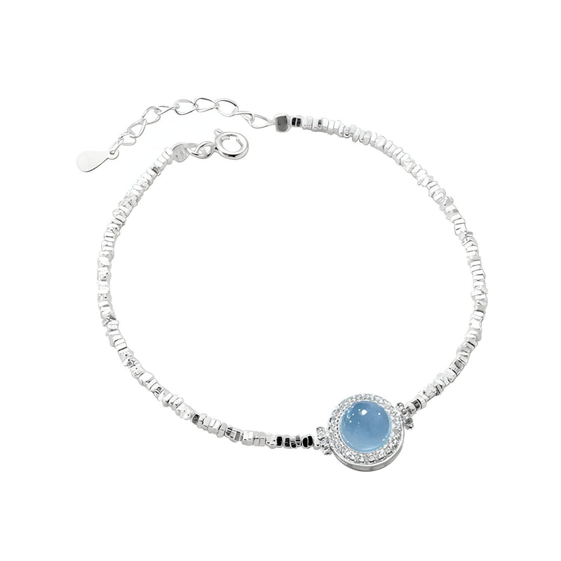 Bracelet fin en argent sterling avec pierre ronde d'aigue-marine bleue et détails texturés.