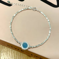 Bracelet argent sterling avec pierre d'aigue-marine ronde sertie, style délicat et élégant pour femme.