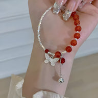 Bracelet argent sterling avec pierres d'agate rouge et pendentif papillon détaillé.