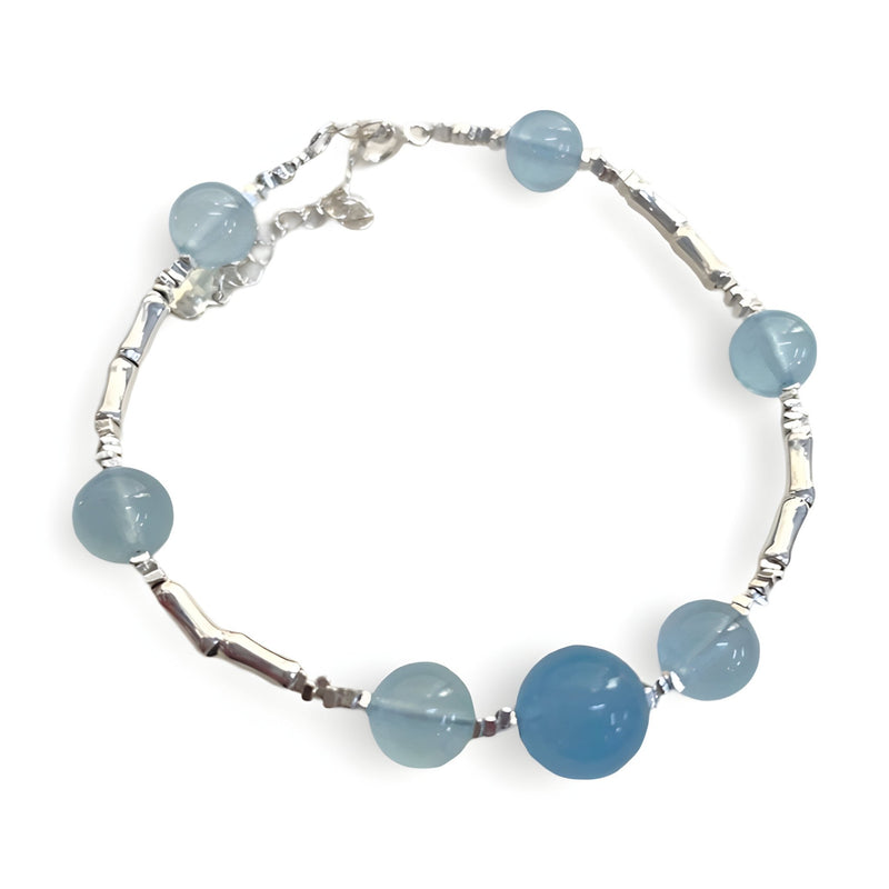 Bracelet en argent sterling avec sept pierres d'aigue-marine bleues rondes, style délicat et élégant.