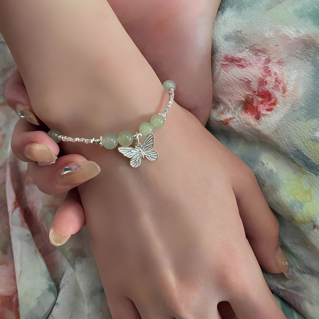 Bracelet en argent sterling avec pierres de jade vert pâle et pendentif papillon délicat.