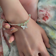 Bracelet en argent sterling avec pierres de jade vert pâle et pendentif papillon délicat.