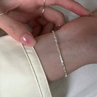 Bracelet fin en argent sterling avec petites pierres brillantes, style délicat et élégant.