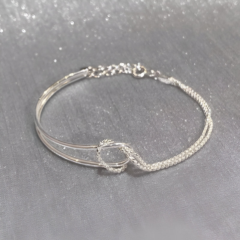 Bracelet en argent sterling avec design à nœud minimaliste et chaîne fine ajustable.