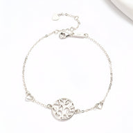 Bracelet argent sterling fin avec pendentif arbre de vie en cercle ajouré et petits cœurs aux extrémités.