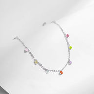Bracelet en argent sterling fin avec petites pierres de zircon multicolores suspendues.