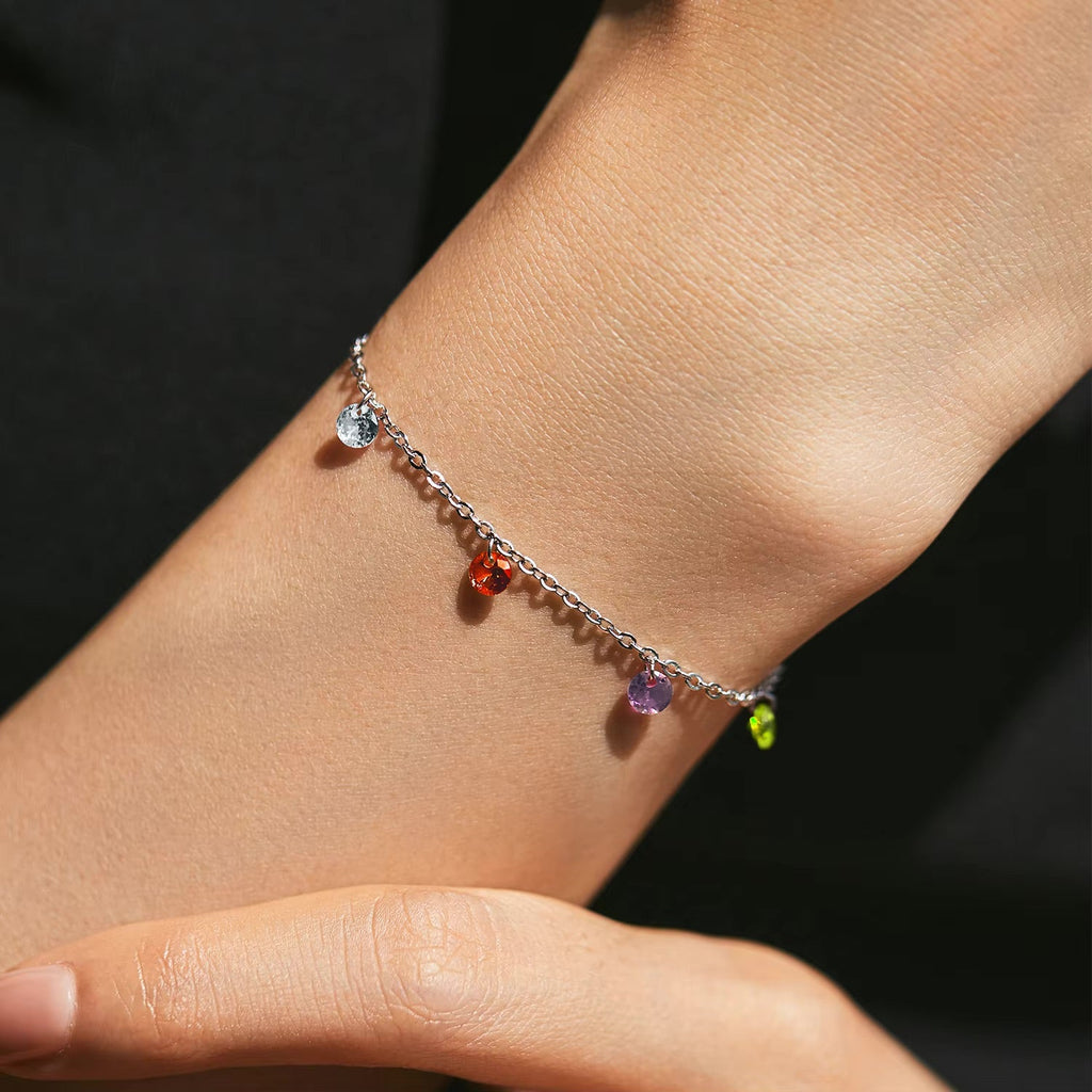 Bracelet fin en argent sterling avec pendentifs en zircon multicolores suspendus en chaîne délicate.