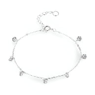 Bracelet fin en argent sterling avec petites breloques rondes serties de zircons délicats.