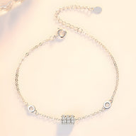 Bracelet fin en argent sterling avec charm cylindrique orné de petits cristaux brillants.