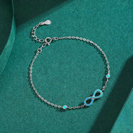 Bracelet en argent avec pendentif infini orné de turquoises, chaîne fine ajustable.