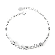 Bracelet en argent sterling avec charms étoiles et fleurs, chaîne fine à maillons allongés.