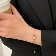 Bracelet en titane or rose avec duo de cercles entremêlés et chiffres romains, design fin et élégant.